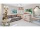 Living room features neutral walls, tile floors, a gray couch, and unique antique furnishings at 4856 Jacaranda Heights Dr, Venice, FL 34293
