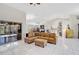 Spacious open-plan living area featuring vaulted ceilings, tile floors, and a comfortable leather sectional sofa at 4856 Jacaranda Heights Dr, Venice, FL 34293