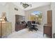 Cozy home office featuring tile floors, a wooden desk, and a beautiful arched window at 4856 Jacaranda Heights Dr, Venice, FL 34293