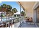 Charming balcony area offers a view of lush greenery, a refreshing pool, and a cozy seating arrangement at 5031 N Beach Rd # 118, Englewood, FL 34223