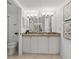 Bright bathroom features double sinks, granite countertops, and white cabinetry for a clean, modern look at 5031 N Beach Rd # 118, Englewood, FL 34223