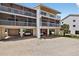 Multi-story condo building featuring covered parking spaces and screened-in balconies, offering both convenience and outdoor living at 5031 N Beach Rd # 118, Englewood, FL 34223