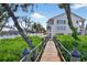 Beautiful house with lush green surroundings and a wooden pathway leading to the charming home at 5031 N Beach Rd # 118, Englewood, FL 34223