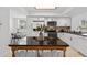 A well-lit kitchen features white cabinets, stainless steel appliances, and a central island table with seating at 5031 N Beach Rd # 118, Englewood, FL 34223