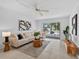 Inviting living room with a cozy sectional sofa, decorative accents, and a sliding glass door to the balcony at 5031 N Beach Rd # 118, Englewood, FL 34223