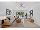 Bright living room with comfortable seating, stylish decor, and access to a private balcony at 5031 N Beach Rd # 118, Englewood, FL 34223
