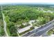 Aerial view of community near highway and nature preserve with multiple trees and lake at 5106 S Lockwood Ridge Rd, Sarasota, FL 34231
