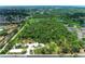 An aerial view of a small park and surrounding nature preserve with lush green trees and serene ponds at 5106 S Lockwood Ridge Rd, Sarasota, FL 34231