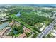 Aerial view featuring community near highway and nature preserve with multiple trees and two small lakes at 5106 S Lockwood Ridge Rd, Sarasota, FL 34231