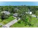 Aerial view of a modest home with a spacious lawn and mature trees surrounding the property at 5106 S Lockwood Ridge Rd, Sarasota, FL 34231