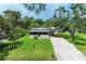 Charming single-story home with a long concrete driveway and lush green lawn at 5106 S Lockwood Ridge Rd, Sarasota, FL 34231