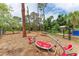 Community playground features a modern seesaw surrounded by tall trees and a mulch surface at 5106 S Lockwood Ridge Rd, Sarasota, FL 34231