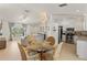 Bright dining area flows into living room, featuring modern chandelier and seating for four at 5264 Albion Rd, Venice, FL 34293