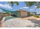 View of the side exterior highlighting the two-car garage, gravel driveway, and partial shade awning at 5264 Albion Rd, Venice, FL 34293