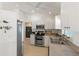 Bright kitchen features white cabinets, stainless steel appliances, and light wood flooring at 5264 Albion Rd, Venice, FL 34293