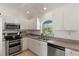 Bright kitchen features white cabinets, stainless steel appliances, and an arched window at 5264 Albion Rd, Venice, FL 34293