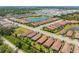 Wide aerial shot featuring homes with tile roofs surrounding a lake in a planned community at 5856 Semolino St, Nokomis, FL 34275