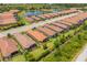 Aerial view of homes with tile roofs and lanais in a well-maintained community with a lake at 5856 Semolino St, Nokomis, FL 34275