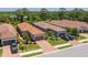 Aerial view of homes with tile roofs, brick driveways, and manicured lawns at 5856 Semolino St, Nokomis, FL 34275