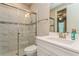 Bathroom with walk-in shower, brushed metal hardware, and white cabinets at 5856 Semolino St, Nokomis, FL 34275