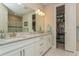 Bathroom with granite countertops, white cabinets, walk-in closet, and dual sinks at 5856 Semolino St, Nokomis, FL 34275