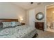 Comfortable bedroom with accent mirror and view into the bathroom at 5856 Semolino St, Nokomis, FL 34275