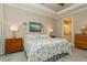 Bright bedroom features tray ceiling, neutral walls, and a view of the connected bathroom at 5856 Semolino St, Nokomis, FL 34275