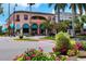 A picturesque corner building with pink facade, awnings, and vibrant floral displays at 5856 Semolino St, Nokomis, FL 34275