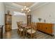 Formal dining room boasts wood flooring, elegant chandelier, and wood furniture at 5856 Semolino St, Nokomis, FL 34275