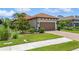 Charming home featuring a tile roof, well-manicured landscaping, and a brown two-car garage at 5856 Semolino St, Nokomis, FL 34275