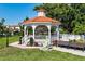 Charming gazebo with orange tile roof and seating, surrounded by lush greenery and landscaping at 5856 Semolino St, Nokomis, FL 34275