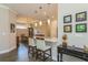 Open-concept kitchen featuring a granite countertop island, stainless steel sink, and a view of the dining area at 5856 Semolino St, Nokomis, FL 34275