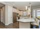 Well-lit kitchen with white cabinetry, stainless steel refrigerator, granite countertop, and pendant lighting at 5856 Semolino St, Nokomis, FL 34275