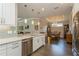 Open kitchen features white cabinetry, granite countertops, stainless steel appliances, and overlooks dining area at 5856 Semolino St, Nokomis, FL 34275