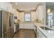 Modern kitchen showcases white cabinets, tile backsplash, granite counters, and stainless steel appliances at 5856 Semolino St, Nokomis, FL 34275