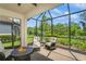 Screened lanai with brick pavers features a fire pit and comfortable seating overlooking the lush backyard at 5856 Semolino St, Nokomis, FL 34275