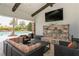 This outdoor lounge has a stone fireplace, TV, and comfortable seating near the pool area at 5856 Semolino St, Nokomis, FL 34275