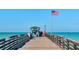 View of a pier with Papa's bait and tackle shop and the American flag waving in the background at 5856 Semolino St, Nokomis, FL 34275