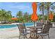 Relax in comfortable poolside seating, complete with table, umbrella, and view of the pool at 5856 Semolino St, Nokomis, FL 34275