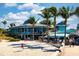 Beachfront restaurant with outdoor seating, surrounded by palm trees and blue skies at 5856 Semolino St, Nokomis, FL 34275