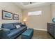 Den with blue couch, wooden floors, a small window, and wall decor at 5856 Semolino St, Nokomis, FL 34275