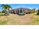 Expansive backyard showcasing a screened-in lanai, lush landscaping, and well-maintained lawn, offering a serene outdoor space at 5868 Jefferson Rd, Venice, FL 34293