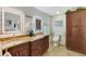 Bathroom featuring double sinks, wood cabinetry, and decorative wall art at 5868 Jefferson Rd, Venice, FL 34293
