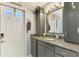 Well-lit bathroom features granite countertops, neutral paint, gray cabinets and updated fixtures at 5868 Jefferson Rd, Venice, FL 34293