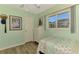 Light green bedroom with a twin bed, white dresser, and neutral wood-look flooring at 5868 Jefferson Rd, Venice, FL 34293