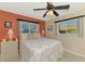 Comfortable bedroom has ample natural light, a ceiling fan, and a tropical theme at 5868 Jefferson Rd, Venice, FL 34293