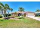 Charming single-story home boasts lush landscaping, palm trees, and a well-maintained lawn at 5868 Jefferson Rd, Venice, FL 34293
