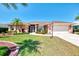 Beautiful single-story home with well-manicured lawn, mature trees, and a two-car garage at 5868 Jefferson Rd, Venice, FL 34293