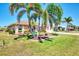 Inviting single-story home with mature palm trees, manicured lawn, and well-maintained landscaping at 5868 Jefferson Rd, Venice, FL 34293