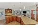 Open kitchen with granite counters, wooden cabinetry, and stainless appliances overlooking the living room at 5868 Jefferson Rd, Venice, FL 34293